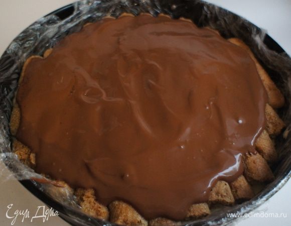 Достать форму с тортом из холодильника. И уложить в него еще один слой печенья с кофе. Полить шоколадом.