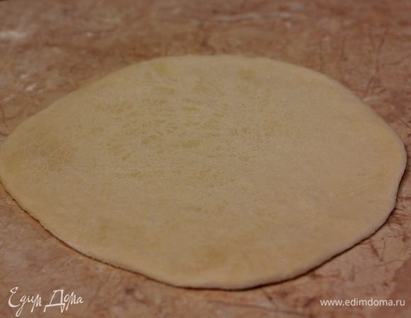 Теперь раскатайте шарик теста. Остальные шарики лучше прикрыть пленкой или бумагой. Диаметр "блинчика" должен получиться около 15 сантиметров.