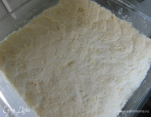 Форму для выпечки смазать сливочным маслом. Выложить 2/3 крошки. Пальчиками аккуратно утрамбовать, сделать бортики.