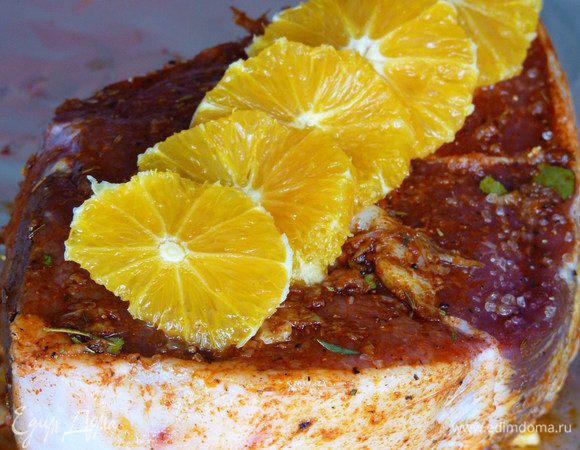 Нагреваем духовку до 210 С. Тем временем очищаем от кожуры и верхней пленки апельсин и нарезаем его на кружочки. Выкладываем поверх мяса и аккуратно и плотно оборачиваем в фольгу. Заворачиваем еще в один слой фольги. Кладем в жаропрочную посуду и выпекаем в разогретой духовке 1 ч. 45 мин.