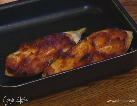 Баклажан разрезать вдоль пополам, выложить на противень срезами вверх и смазать соевой заправкой. Запекать в разогретой духовке 15 минут.