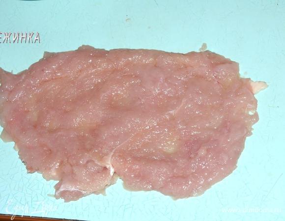 Куриную грудку отделить от кости, чтобы получилось 2 филе. Делая надрезы в толстых местах мяса раскрыть каждое филе как книгу. Отбить их между двумя пластами пищевой пленки в виде длинных прямоугольников.