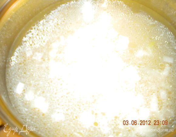 В кастрюле разогреть масло и обжарить на нем заранее мелко нарезанный лук и чеснок.
Влить куриный бульон и довести до кипения.