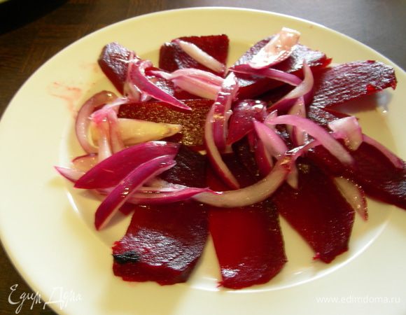 Собираем нашу закусочку, На тарелки выкладываем свеклу, порезанную тонкими кружочками, и лук. Поливаем их заправкой.
