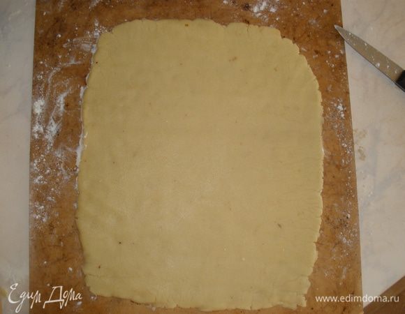 Далее удобнее всего его сразу же раскатать на пергаменте (промасленном), на котором потом оно будет выпекаться. Тесто раскатываем в как можно более ровный прямоугольник. Это сократит количество "отходов". При этом скалка и тесто должны быть хорошо присыпаны мукой. Убираем на 1 час в холодильник.