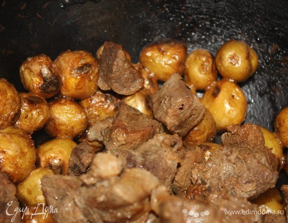 Когда картофель приготовится, добавить к нему тушеную говядину, каплю жидкого дыма и дать несколько минут еще протомиться.