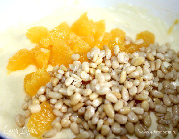 С апельсина срезать кожицу и небольшое количество мякоти.Из апельсинных долек вырезать только мякоть.Добавить в тесто кусочки апельсинов и кедровые орешки.