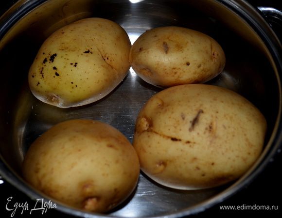 Сварить картофель в кожуре.