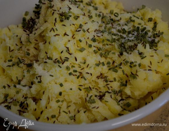 Когда картофель слегка остынет,снять кожуру и протереть через крупную терку. Добавить зеленый лук /стрелки/ порезанный, тмин,соль и белый перец,перемешать.