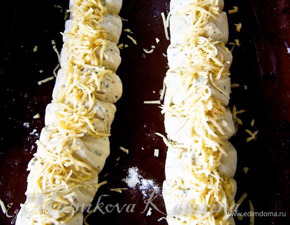 Оставить сформированный хлеб в теплом и укромном месте на 30-40 минут для подхода. Присыпать сверху оставшимся сыром, натертым на мелкой терке. 