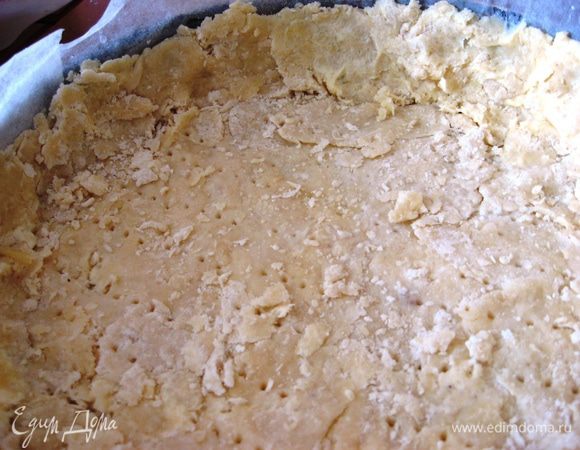 Форму для выпечки выстилаем пергаментной бумагой. Выкладываем раскатанное тесто, делаем бортики. Вилочкой делаем дырочки. Выпекаем в духовке 15 минут при 180 градусах.