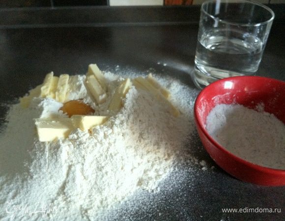 Начнем с теста.
К просеяной через сито муке добавляем мелко порезанное масло и желтки и смешиваем, постепенно добавляя воду вымешиваем тесто.