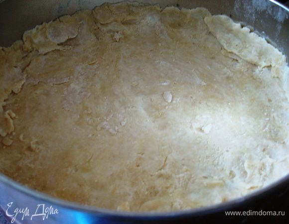 Раскатать половинку теста на присыпанной мукой поверхности, толщина должна быть 4-6 мм. Выложить в форму, смазанную растительным маслом (у меня форма диаметром 25 см). Сделать небольшие бортики. Накрыть пленкой и поставить на 10 минут в холодильник. 