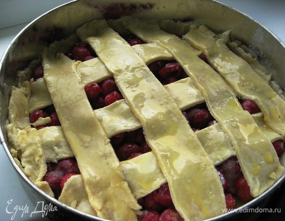 Духовку разогреть до 180 градусов. Молоко смешать с желтком и смазать верх пирога. 