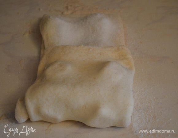 Далее не раскатываем, присыпаем все 1/4 частью сахара и также зрительно жделим на 3 части. Нижней частью накрываем центр