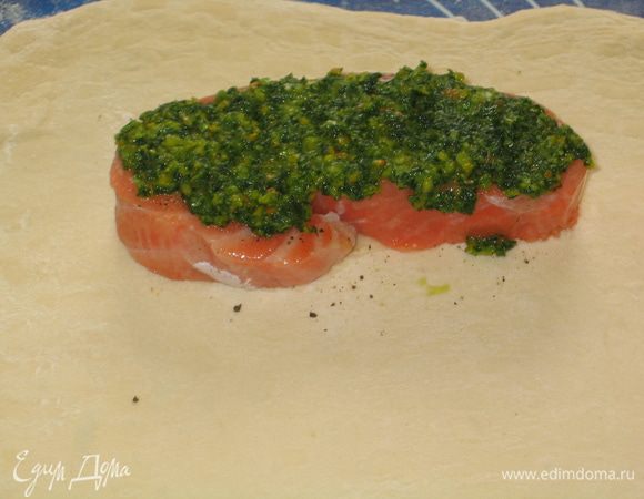 Каждый пласт теста разделить пополам и немного растянуть вширь. Уложить на одну половину кусок семги, поверх него выложить начинку 