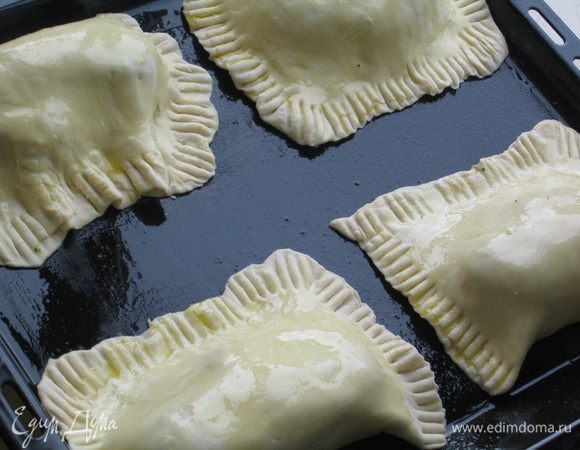 Уложить конвертики на противень, смазанный маслом, и сверху также смазать маслом с помощью кисточки