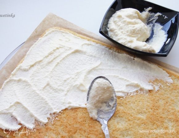Возвращаемся к рулету, "отделяем" пергамент, но не убираем его, продолжаем действо прямо на нем. Наносим белоснежный крем, оставляем парочку ложек для украшения.
