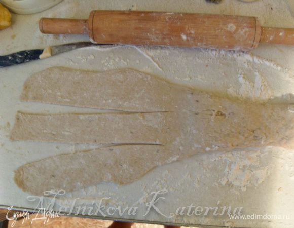 Раскатать скалкой лепешку только до половины. Раскатанную часть разрезать ножом на три равные части. 