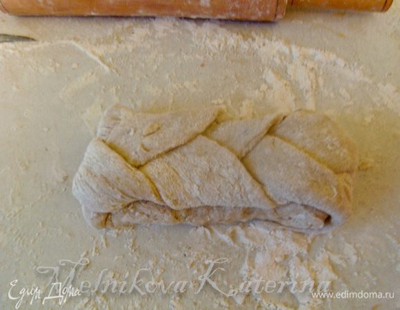 Выложить косу на не раскатанную часть, концы загнуть под низ лепешки. Аналогичные действия повторить и со второй частью теста. Должно получиться две булки. 