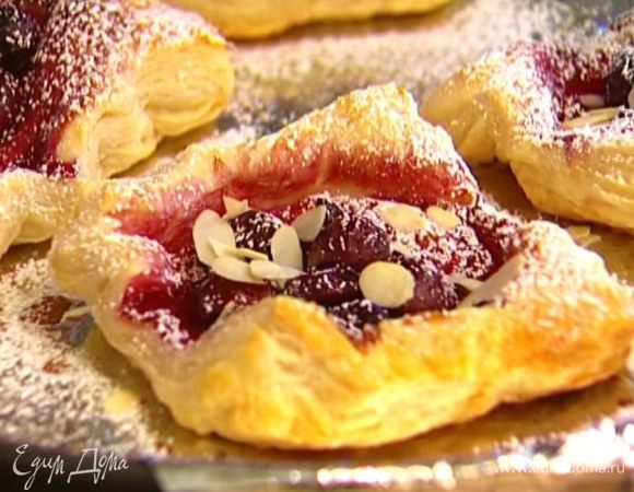 Вынуть плюшки из духовки, присыпать оставшейся сахарной пудрой и миндальными лепестками.