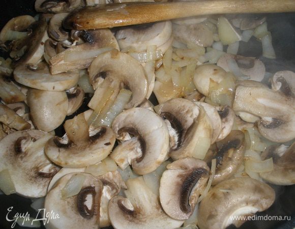 Для начинки обжарить на сливочном масле лук. Добавить грибы и жарить на среднем огне примерно 10 минут до выкипания жидкости. 