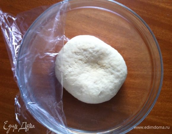 Смешать дрожжи, соль и 150 г муки. В теплую воду (около 50 градусов) влить масло. Аккуратно влить жидкость в муку, все время перемешивая. Постепенно добавить оставшуюся муку и месить тесто до мягкой и эластичной консистенции. Миску накрыть пленкой и оставить на 15 минут.