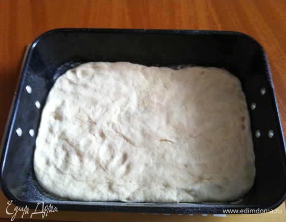 Выложить тесто на противень и разровнять руками. Накрыть пленкой и оставить в теплом месте на 30 минут, пока не увеличится в объеме вдвое.