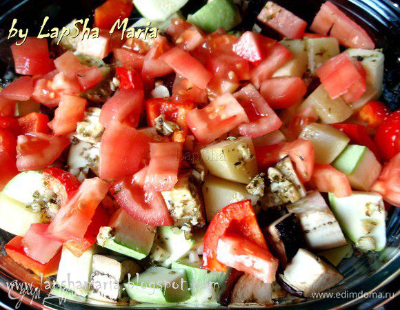 С помидора снимаем кожицу и нарезаем на небольшие кубики, кладем сверху овощей и запекаем ещё 20 минут.