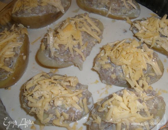 Нафаршировать картофель. Выложить в смазанную маслом форму для запекания, полить соусом. На картофль выложить оставшийся тертый сыр. Запекать при 200 градусах 30 минут. 