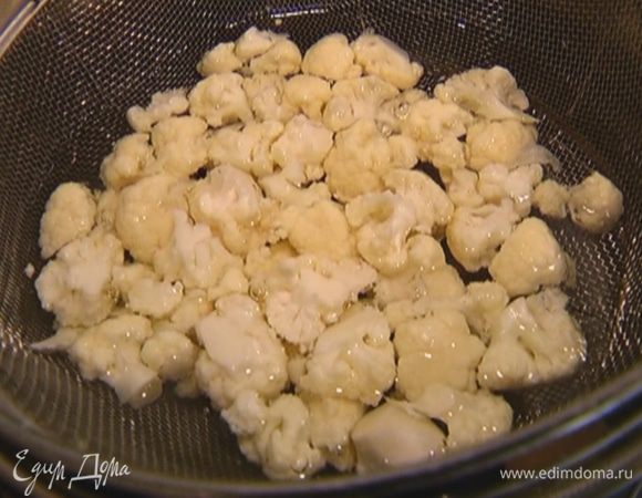 Цветную капусту разобрать на мелкие соцветия, выложить в сито и подержать в кипящей воде 2–3 минуты, а затем вынуть.