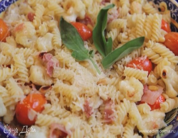 Выложить макароны в блюдо, сбрызнуть оставшимся оливковым маслом, посыпать орехами и натертым сыром.