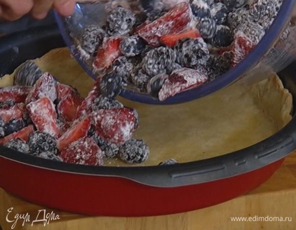 Достать форму из духовки, убрать бумагу с горохом, выложить на корж ягоды и выпекать пирог еще 20 минут.