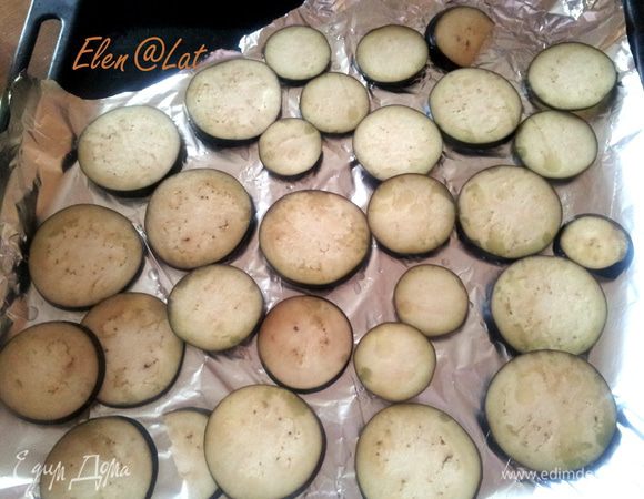 Пока поднимается тесто, надо подготовить баклажаны. Для этого их помыть, нарезать на тонкие кружки и выложить на противень, застеленный фольгой, смазать сверху оливковым маслом. Выпекать баклажаны нужно в течении 10-15 минут при 200С. Лучше включить гриль.