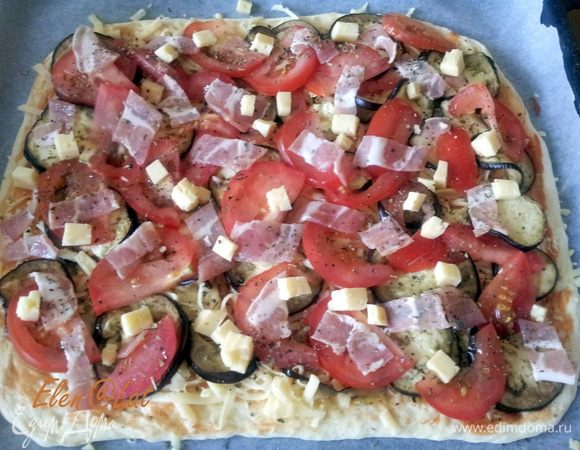 Также тонко нарезать бекон, и положить кубики брынзы. Посыпать все сухим орегано, базиликом и перцем.