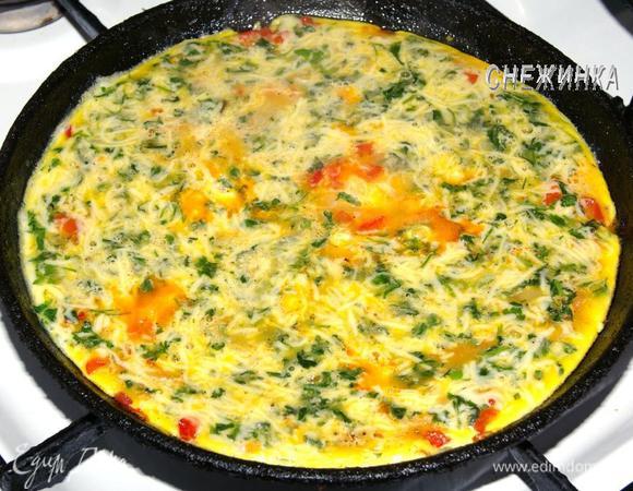 Теперь влейте яичную массу и жарьте на небольшом огне, пока у стенок омлет не начнет схватываться.