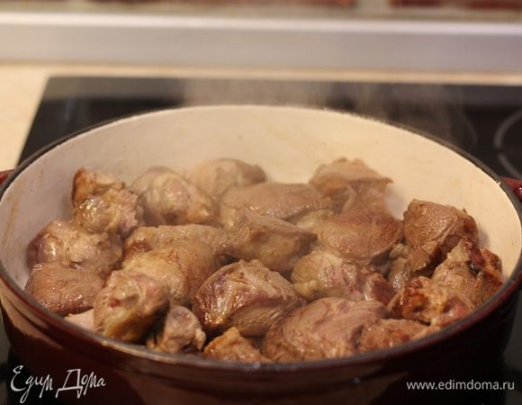 Если вы жарили мясо в несколько этапов - выложите все обжаренное мясо обратно в кастрюлю. Уменьшите огонь до маленького.