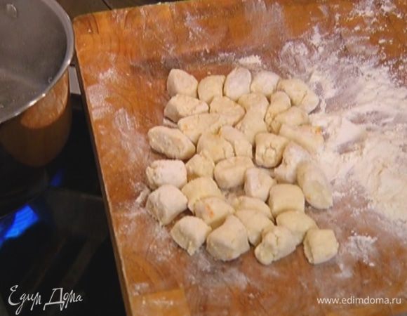 Оставшейся мукой присыпать рабочую поверхность, выложить творожное тесто, сформировать колбаски и нарезать их небольшими кусочками.