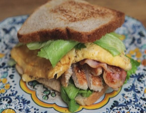 Оба куска хлеба смазать горчицей, выложить на один из них салатные листья, омлет, бекон, индейку и накрыть вторым куском.