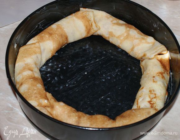 Форму для выпекания хорошо смазать сливочным или растительным маслом. Выкладывать рулетики из блинов от края формы к середине.