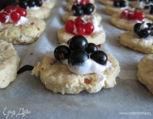 Смазываем каждое печенье небольшим количеством безе, а сверху - по 4-5 ягод смородины. Можно использовать и другие ягоды с кислинкой, по вкусу.  