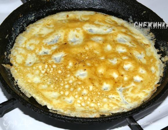 Когда края яйца начнут подсыхать и золотиться, убираем сковороду с огня, даем постоять 20 секунд, и осторожно переворачиваем омлет на другую сторону. Дожариваем 30 секунд.