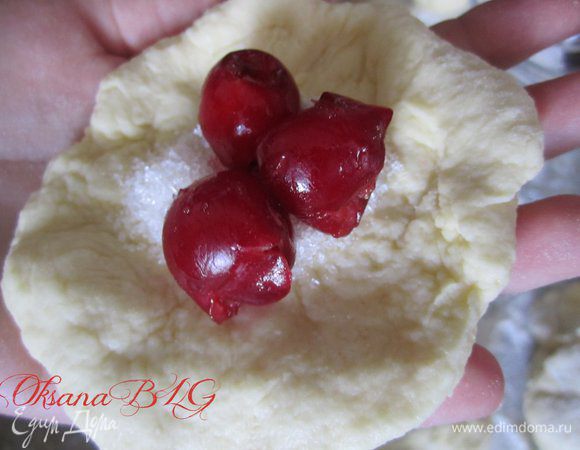 Сформировать пончики.Из теста сформировать небольшую лепешку, положить 1/2 ч.л. сахара, вишню, аккуратно зашипить края, сформировав шарик.