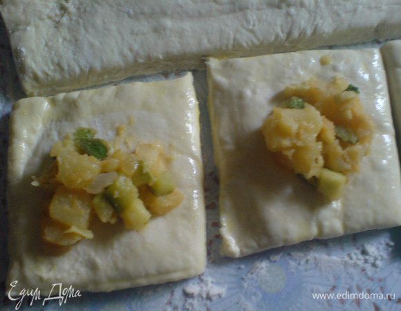 Тесто нарезать на небольшие квадратики.Края смазать яйцом,взбитым с водой.Мяту вымыть,порвать или порезать и добавить в начинку.В центр каждого квадратика положить немного начинки.Сложить квадраты и закрыть края.