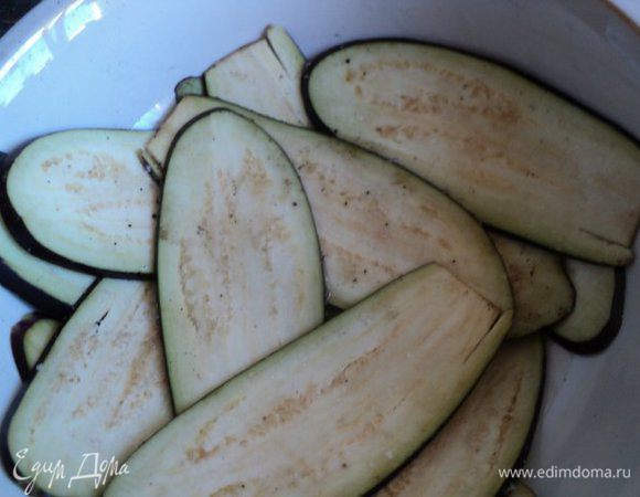 Баклажаны помыть, отрезать хвостики и порезать тонкими пластинками. Я нарезала при помощи специальной терки. Посолить и оставить на 10 мин., пока баклажаны пустят сок. Затем промыть, обсушить, посыпать белым перцем.