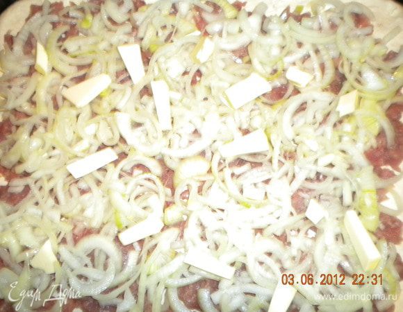 Делим тесто на две неравные части. Одну (ту которая побольше) раскатываем и выкладываем на противень. Выкладываем фарш, солим (немного), перчим, сверху выкладываем лук. Сливочное масло нарезаем ломтиками и выкладываем на подушку из лука (для сочности).