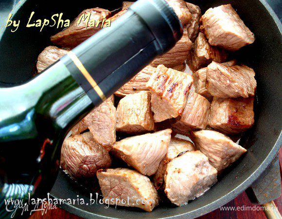 Обжарить говядину на оливковом масле, можно в две порции, чтобы не начало тушиться раньше времени. Перекладываем в небольшую кастрюльку или сковороду с высокими бортами, наливаем вино, накрываем крышкой и оставляем томиться на час. В процессе может потребоваться добавить воду, если вино полностью испариться. 