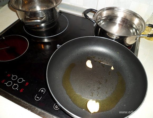 Одновременно вливаем 2 ст.л. оливкового масла на сковороду и обжариваем чеснок до золотистого цвета на среднем огне 2-3 мин