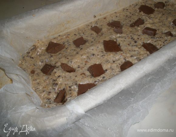 Форму для выпечки смазать маслом, застелить бумагой для выпечки. Я ее смачиваю и мну - так она более пластична. Выложить массу в форму. А сверху выложить кусочки оставшего шоколада. 