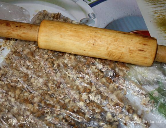 Орехи сложить в пакет и раскрошить скалкой.